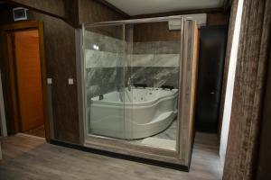 a bathroom with a tub inside of a glass door at Hera Suit Ataşehir in Istanbul