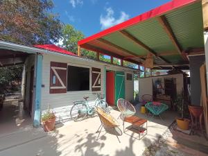 a house with a patio with chairs and a bike at Ma chambre Javanaise in Port-Louis