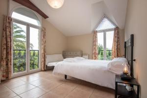 a bedroom with a large bed and large windows at La Zinca in Cambre