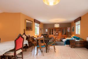 a living room with a table and chairs and a bedroom at La Zinca in Cambre