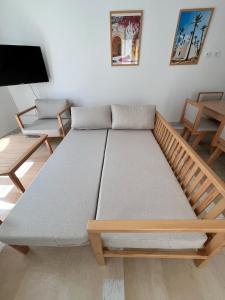 a large bed in a room with a tv at Dar Lisa - Charming authentic beachfront villa in Aghīr