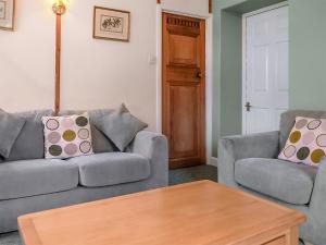 a living room with two couches and a coffee table at Stream Cottage - 27550 in Wheddon Cross