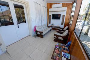 a porch with two chairs and a television on a balcony at Pousada Prime Gramado in Gramado
