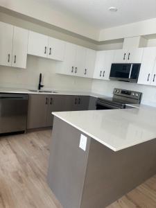 a kitchen with white cabinets and a white counter top at Your private room CozyVibe in Edmonton +7 photos