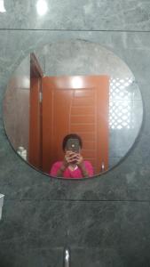 a woman taking a picture of herself in a mirror at Leisure Paradise in Kharar