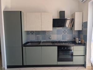 a kitchen with white cabinets and a stove at La Terrazza Sidicina Home in Teano