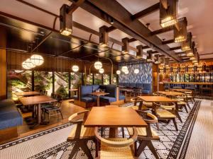 a restaurant with wooden tables and chairs and a library at Mercure Hida Takayama in Takayama