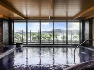 a hot tub in a room with a large window at Mercure Hida Takayama in Takayama