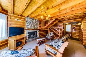 a living room with a fireplace and a tv at Bosque Dormido Cabañas & Spa in San Carlos de Bariloche