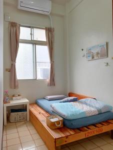 a bedroom with a wooden bed and a window at 拉瓦宅 輕旅店 - Lawa House #僅接待18-35歲青年旅人#Only for aged 18-35 in Chiayi City