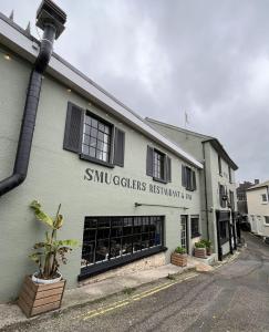 a building with a sign on the side of it at Smugglers Hotel in Brixham