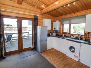 a kitchen with a refrigerator and a dishwasher at Primrose Lodge in Evesham