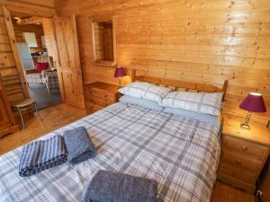 a bedroom with a bed in a log cabin at Primrose Lodge in Evesham