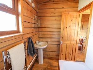 a bathroom with a sink and a wooden wall at Primrose Lodge in Evesham +12 photos