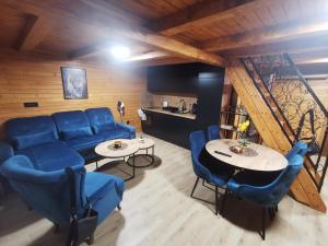 a living room with blue chairs and a table at Koliba Buba in Brčko
