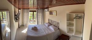 a bedroom with a bed with a table in it at Suíte Atobás in Arraial do Cabo