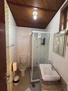 a bathroom with a shower and a sink and a toilet at Suíte Atobás in Arraial do Cabo +11 photos