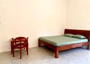 a bed and a chair in a room at Ocean Bungalow in Phú Quốc