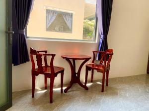 a table and two chairs and a table and a window at Ocean Bungalow in Phú Quốc