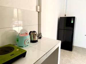a kitchen with a toaster and a black refrigerator at Ocean Bungalow in Phú Quốc