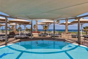a swimming pool with umbrellas and the ocean at InterContinental David Tel Aviv by IHG in Tel Aviv