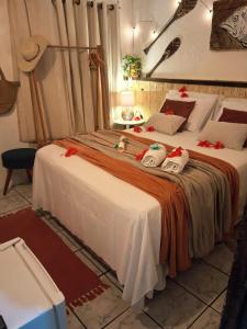 a bedroom with a large bed with towels on it at Casa de Mirtes in Fernando de Noronha