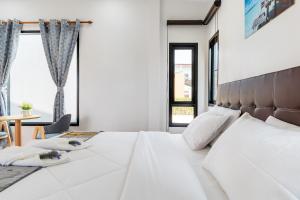 a bedroom with a large white bed and windows at Deluxe Hotel Chaiyaphum in Chaiyaphum +53 photos