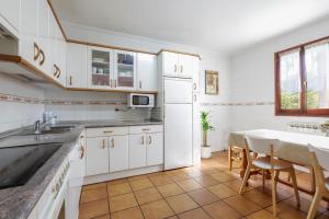 a kitchen with a table and a white refrigerator at LOPENEA Baztan in Garzáin
