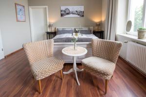 a bedroom with a table and two chairs and a bed at Pension Onken in Bockhorn