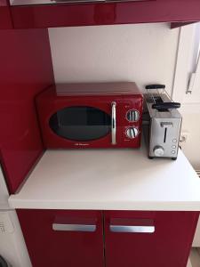 a red microwave sitting on top of a counter at O Chaleco in San Ciprián