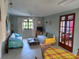 a living room with a couch and a table at Appartement spacieux étage maison avec jardin à Ste Anne in Sainte-Anne