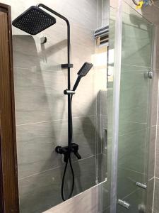 a shower with a shower head in a bathroom at Ehi-Mega Luxury Hotel and Apartment in Abuja