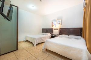 a hotel room with two beds and a mirror at Garza 912 in Carpintero +8 photos