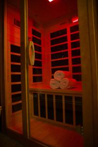 a sauna with red lighting and towels on a shelf at Whole House Aurora View with Hot tub, Sauna and AC in Fairbanks +30 photos