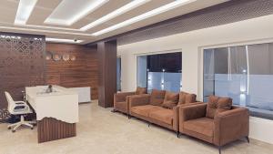a lobby with two chairs and a desk and windows at The Royal Luxe in Kolur