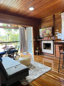 a living room with a couch and a fireplace at Chalé Beijinho in Venda Nova do Imigrante