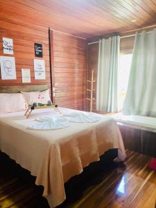 a bedroom with a bed with a wooden wall at Chalé Beijinho in Venda Nova do Imigrante