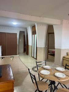 a dining room with a table and chairs and a couch at Appartement Marrakech in Marrakesh