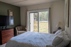 a bedroom with a bed and a sliding glass door at Seasons 103 in Warren