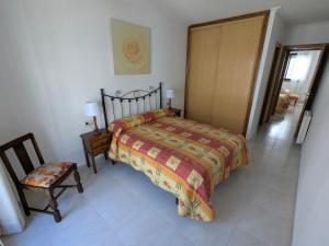 a bedroom with a bed and a chair and a door at L&C Codesal in Sanxenxo +5 photos
