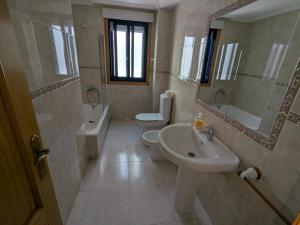 a bathroom with a sink and a toilet and a mirror at L&C Codesal in Sanxenxo