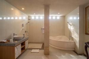 a bathroom with a tub and a toilet and a sink at Aksara Ubud in Ubud