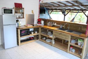 a kitchen with a counter with a sink and a refrigerator at Kaz Manga Rose in Deshaies