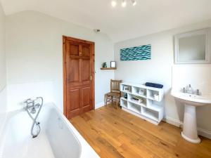 a bathroom with a tub and a sink at 4 Bed in Tenby oc-vv27177 in Manorbier +24 photos