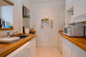 a kitchen with a sink and a microwave at Kames View Apartment in Tighnabruaich
