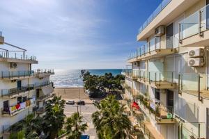 a view of the beach from the balcony of a building at Beachfront Apartment with Pool Access by PikHost in Lezhë