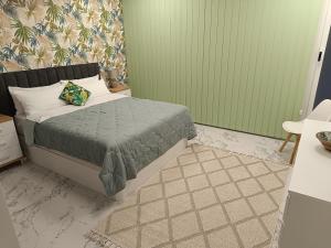 a bedroom with a bed with a green wall at Sylvia Apartman in La Mata
