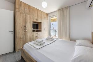 a bedroom with a large bed with wooden cabinets at Beachfront Apartment with Pool Access by PikHost in Lezhë +24 photos