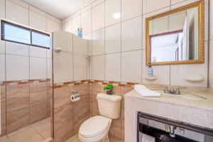 a bathroom with a toilet and a sink and a shower at Casa Sol in Carpintero +9 photos