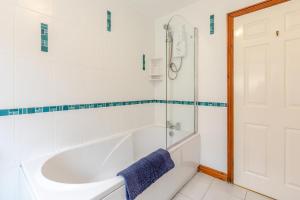 a white bathroom with a tub and a shower at 4 Bed in Croyde oc-sundow in Croyde +20 photos